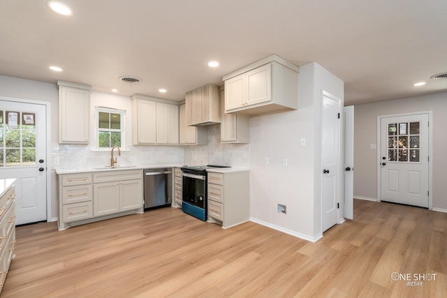 kitchen featuring white cabinets, sink, stainless steel dishwasher, light hardwood / wood-style flooring, and range with electric cooktop