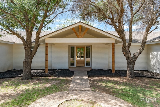 view of front facade with brick siding and a porch