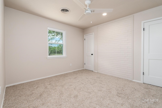 carpeted spare room featuring ceiling fan