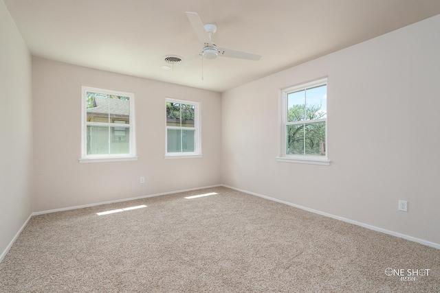 carpeted spare room with ceiling fan and a healthy amount of sunlight