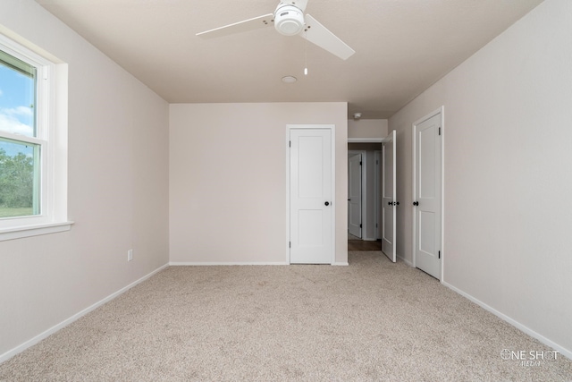 unfurnished room featuring ceiling fan and light colored carpet