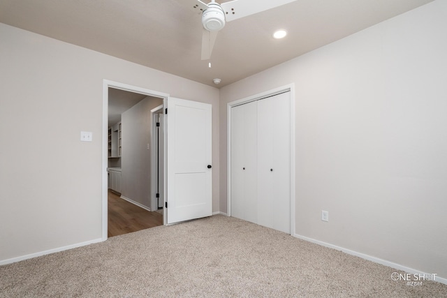 unfurnished bedroom with ceiling fan, light colored carpet, and a closet