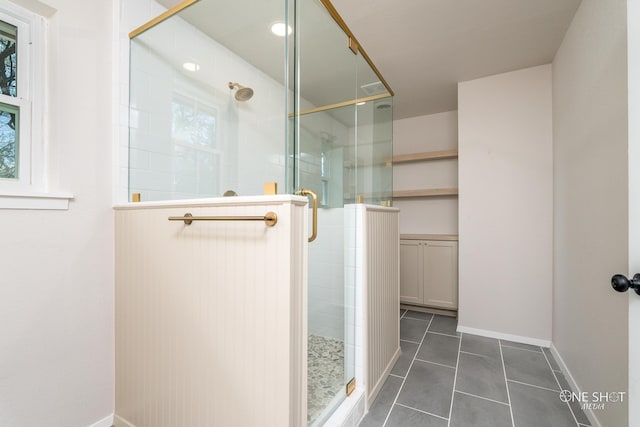 bathroom featuring a shower with shower door and tile patterned flooring