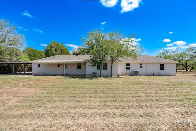 rear view of house with central AC and a yard