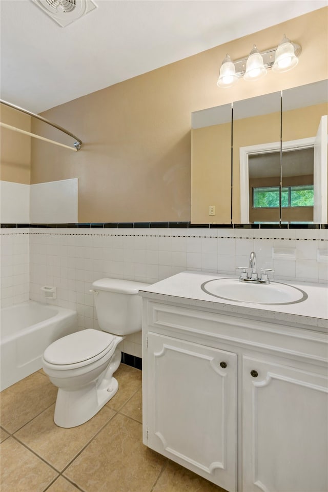 full bathroom with tile walls, tile patterned flooring, bathing tub / shower combination, vanity, and toilet