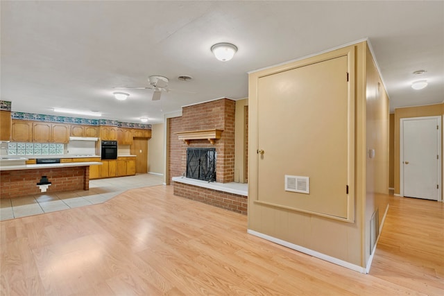 unfurnished living room featuring light wood-type flooring, ceiling fan, and sink