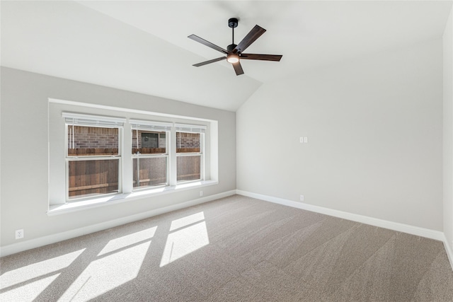 carpeted empty room featuring vaulted ceiling and ceiling fan