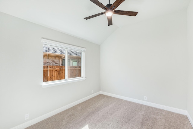 carpeted spare room featuring ceiling fan and vaulted ceiling