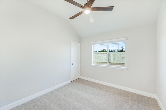 carpeted empty room featuring vaulted ceiling and ceiling fan