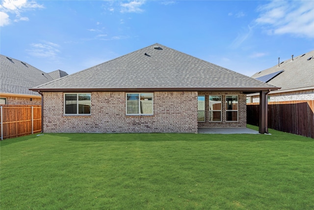 back of house with a lawn and a patio