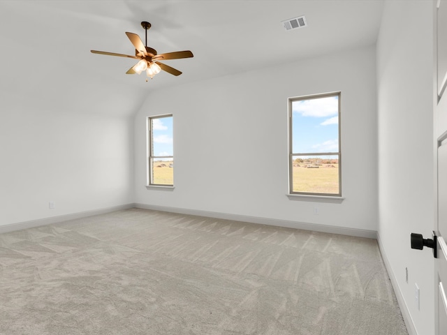 carpeted spare room featuring ceiling fan and vaulted ceiling