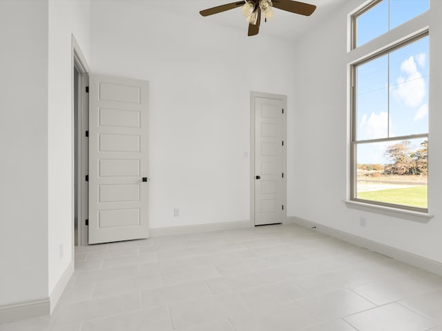 empty room featuring light tile patterned floors and ceiling fan