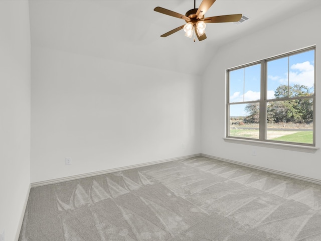 carpeted spare room with ceiling fan and vaulted ceiling