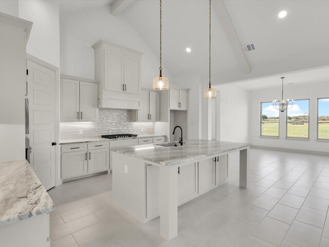 kitchen with a center island with sink, a healthy amount of sunlight, and sink