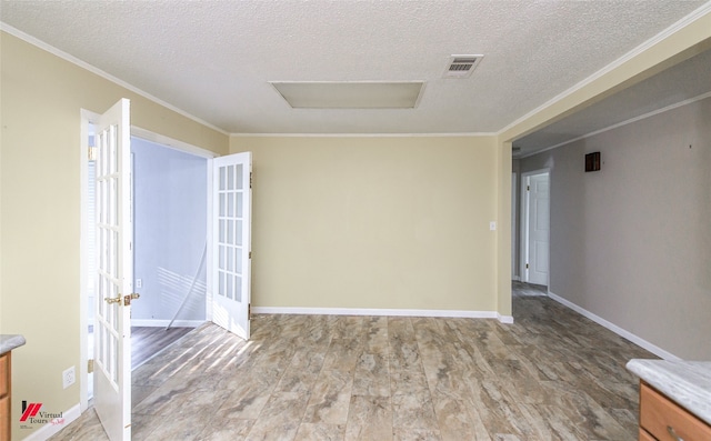 spare room with a textured ceiling, hardwood / wood-style flooring, and crown molding