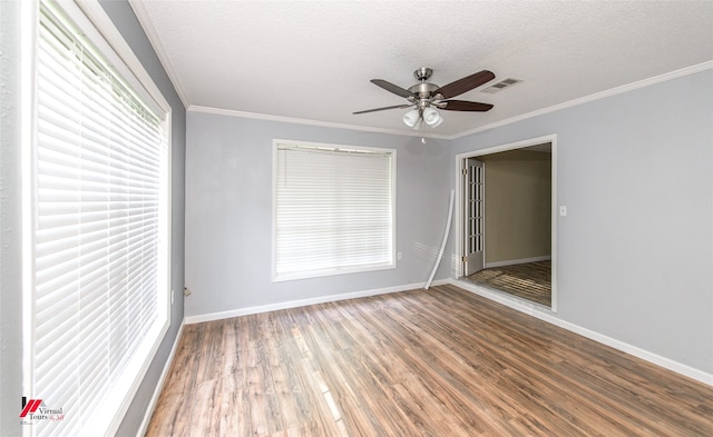 unfurnished room featuring wood-type flooring, ceiling fan, a healthy amount of sunlight, and crown molding