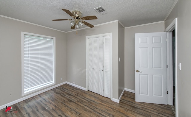 unfurnished bedroom featuring ornamental molding, a closet, ceiling fan, and dark hardwood / wood-style floors