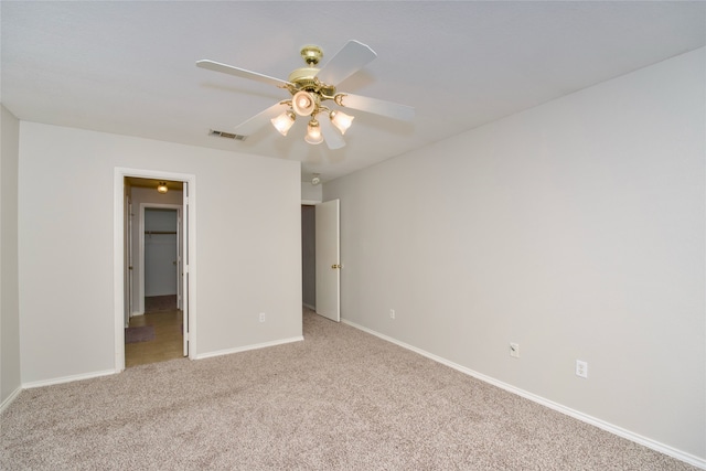 unfurnished bedroom with ceiling fan, light colored carpet, and a spacious closet