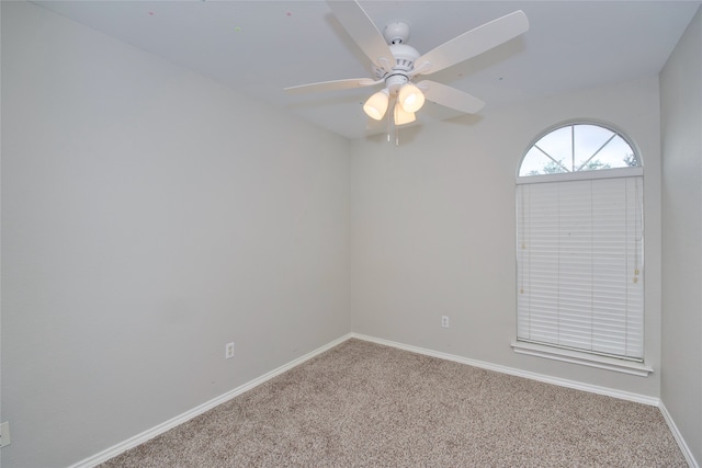 carpeted spare room featuring ceiling fan