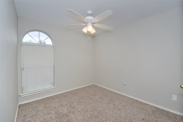 carpeted spare room with ceiling fan