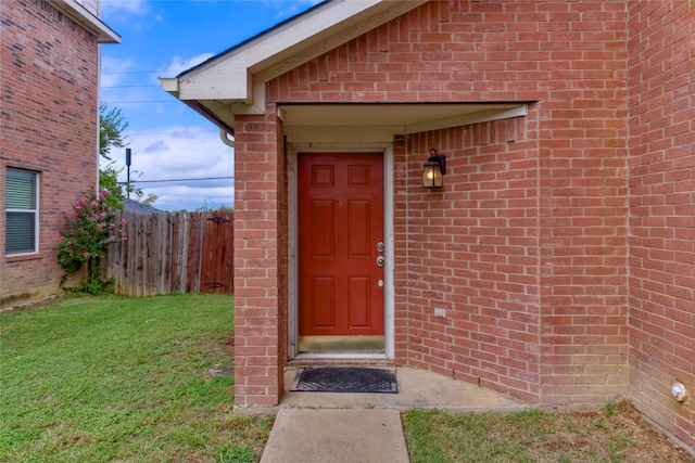 doorway to property featuring a lawn