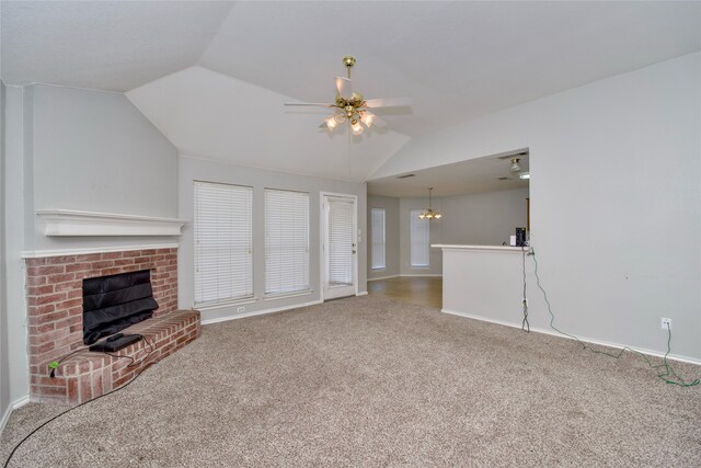 unfurnished living room featuring ceiling fan with notable chandelier, a brick fireplace, carpet, and vaulted ceiling