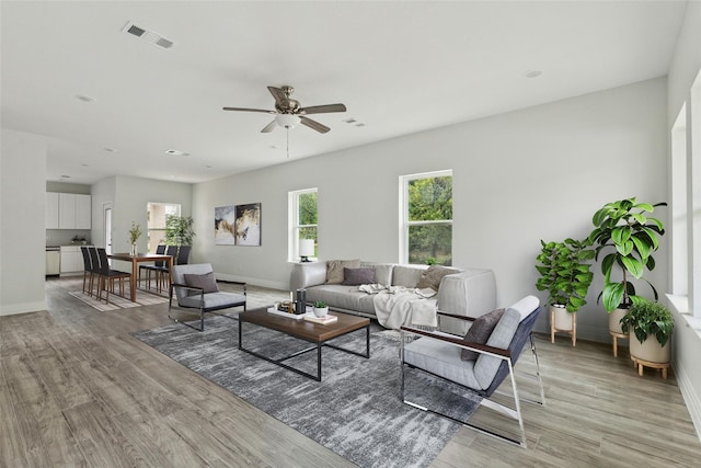 living room with light hardwood / wood-style floors and ceiling fan