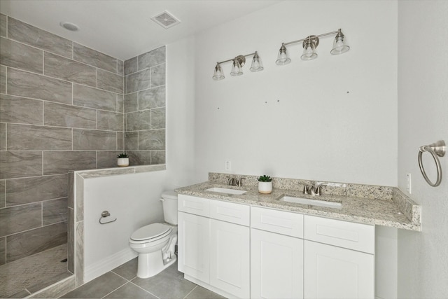 bathroom featuring vanity, tile patterned floors, toilet, and a shower