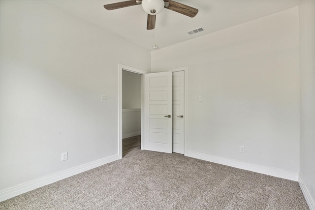 carpeted spare room featuring ceiling fan