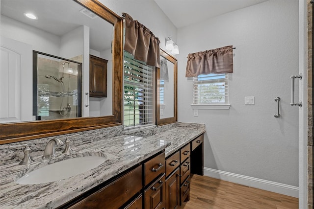 bathroom with a shower with door, vanity, and hardwood / wood-style flooring