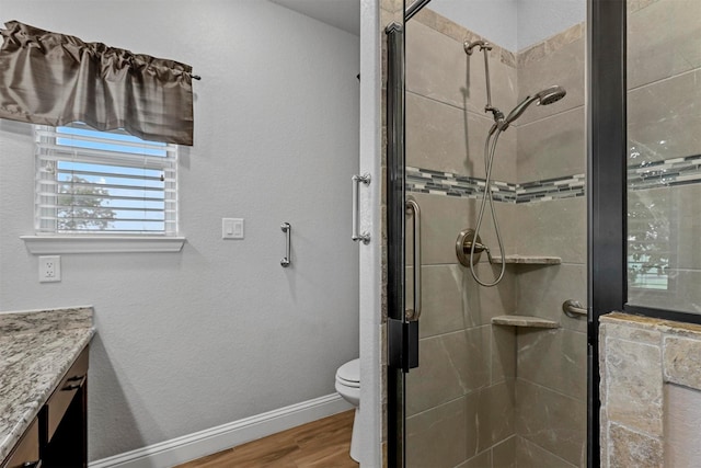 bathroom with vanity, toilet, an enclosed shower, and hardwood / wood-style floors