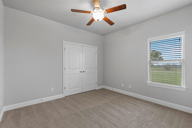 unfurnished bedroom with light carpet, a closet, and ceiling fan