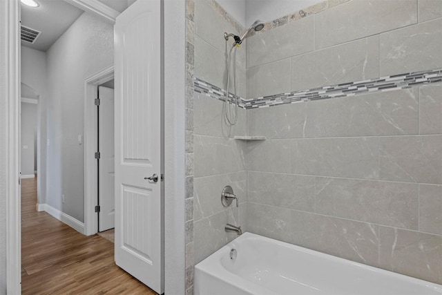 bathroom featuring tiled shower / bath and hardwood / wood-style floors