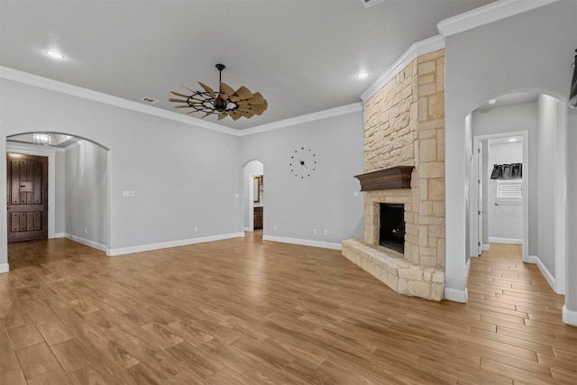 unfurnished living room featuring ornamental molding, a fireplace, ceiling fan, and light hardwood / wood-style flooring