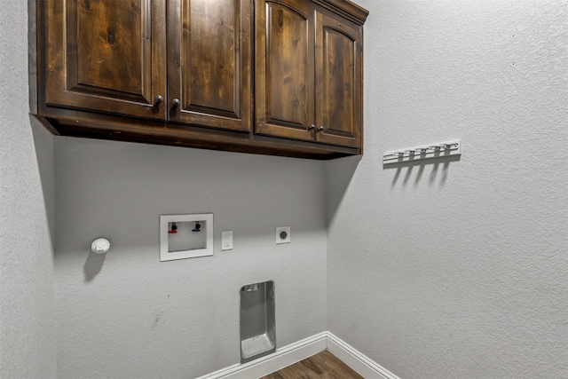 laundry area featuring electric dryer hookup, hardwood / wood-style floors, hookup for a washing machine, and cabinets