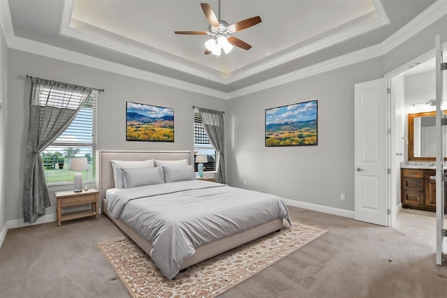 carpeted bedroom with connected bathroom, ornamental molding, a raised ceiling, and ceiling fan