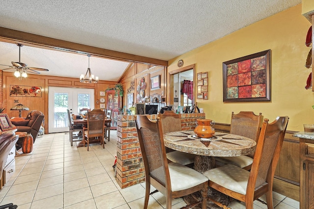 tiled dining room with a textured ceiling, ceiling fan with notable chandelier, and lofted ceiling with beams