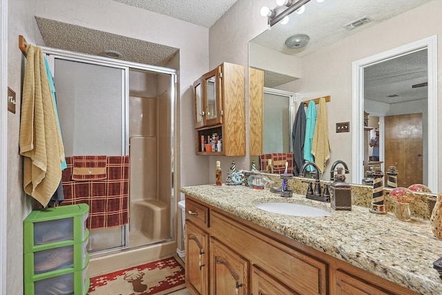 bathroom with vanity, a textured ceiling, and an enclosed shower