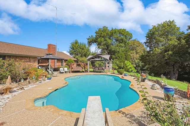 view of swimming pool with a patio, a gazebo, and a diving board