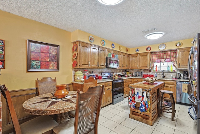 kitchen with decorative backsplash, stainless steel appliances, a textured ceiling, and a kitchen island