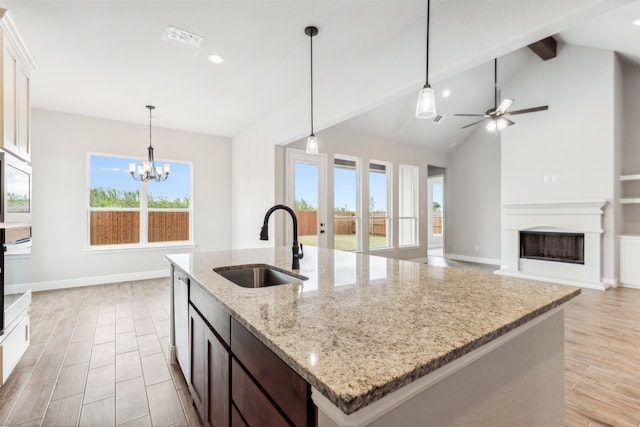 kitchen featuring white cabinets, ceiling fan with notable chandelier, sink, and light stone countertops