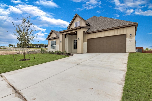 view of front facade featuring a garage, cooling unit, and a front lawn