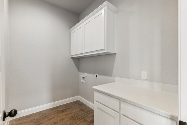 clothes washing area with washer hookup, electric dryer hookup, cabinets, and dark hardwood / wood-style flooring