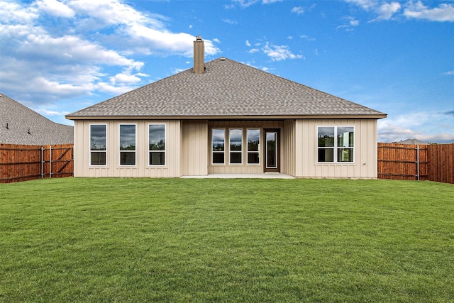 rear view of property with a yard