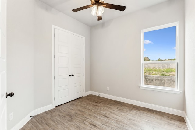 unfurnished bedroom with ceiling fan, a closet, and light hardwood / wood-style flooring