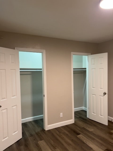 unfurnished bedroom with dark hardwood / wood-style floors