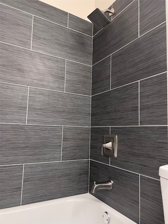 details with toilet and tiled shower / bath