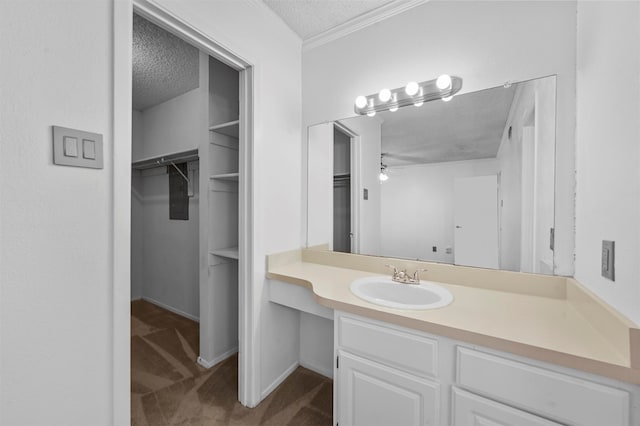 bathroom with ceiling fan, a textured ceiling, and vanity