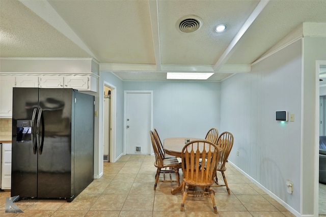 dining space featuring beam ceiling, a textured ceiling, light tile patterned flooring, and crown molding