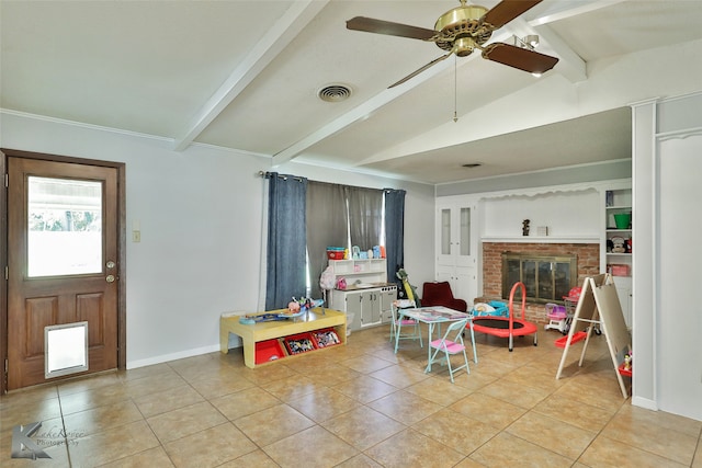 game room featuring a brick fireplace, light tile patterned flooring, lofted ceiling with beams, and ceiling fan